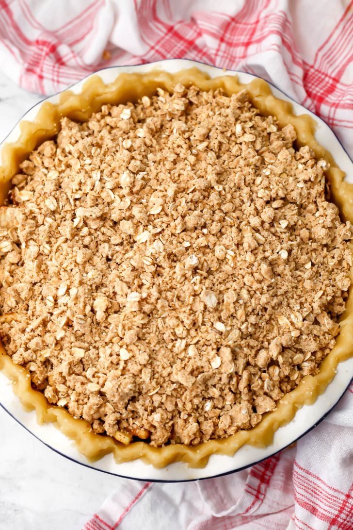 Crumble topping sprinkled on top of a vegan apple pie before baking.