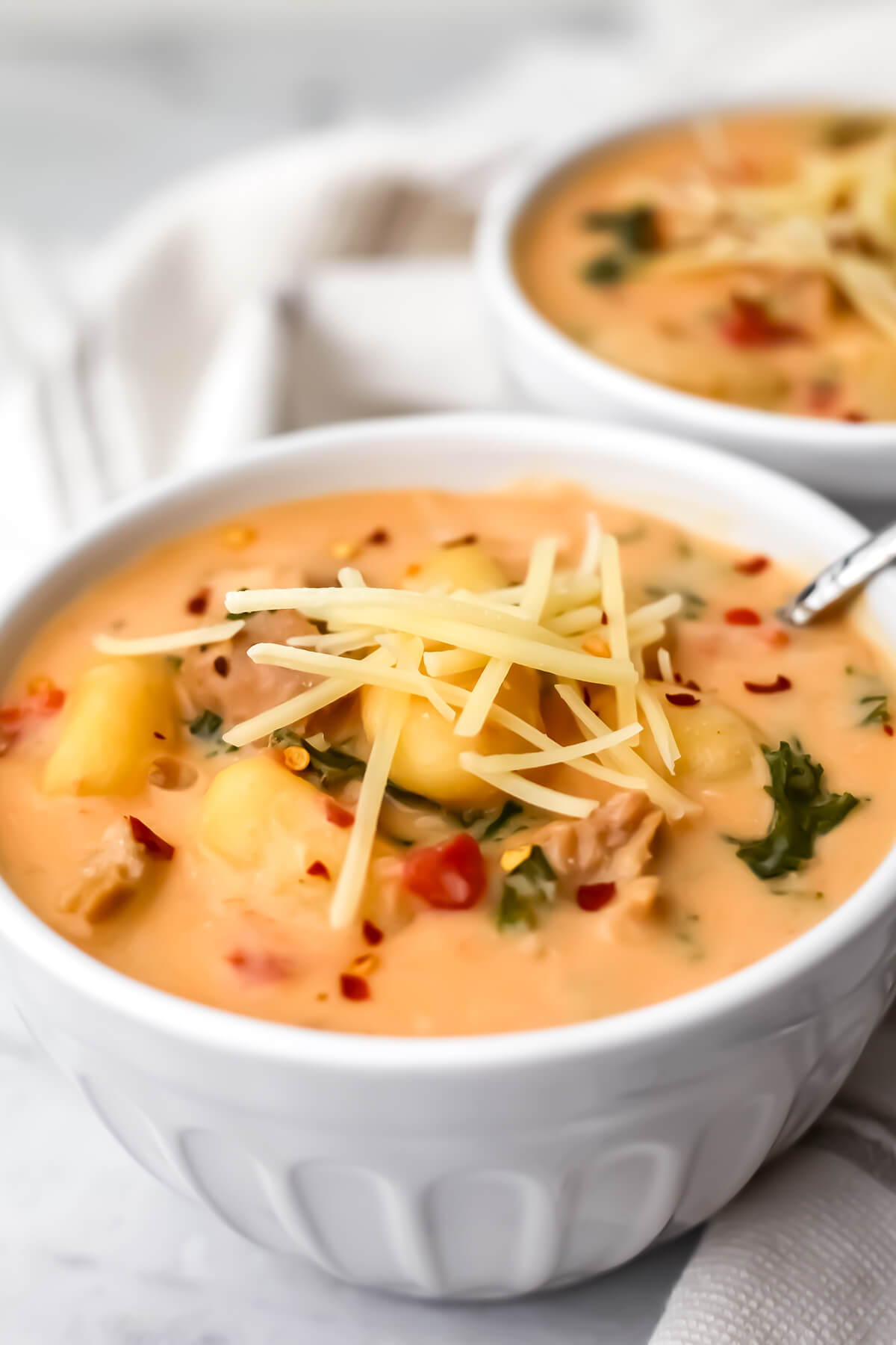 A close up of a bowl of creamy vegan gnocchi soup.
