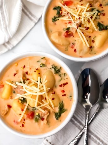 A top view of two bowls of creamy vegan gnocchi soup.