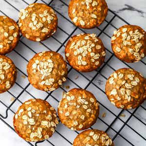 A top view of vegan oat muffins with whole oats sprinkled on top.