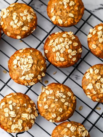 A top view of vegan oat muffins with whole oats sprinkled on top.