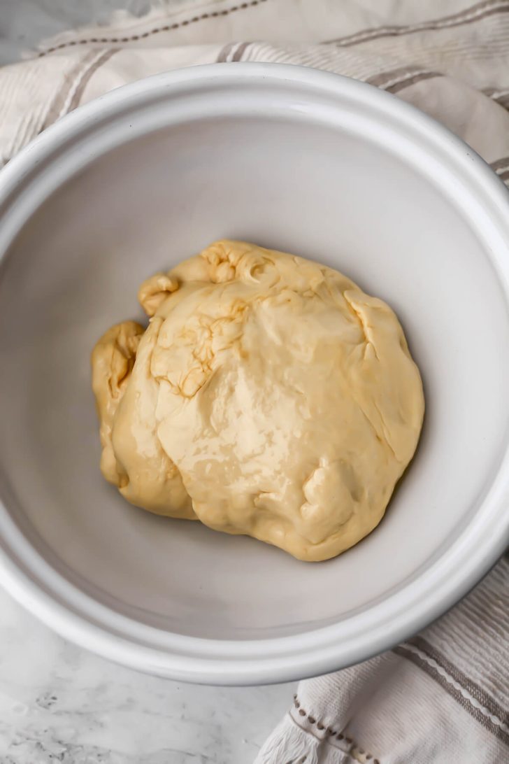 Soft pretzel dough in a greased bowl.