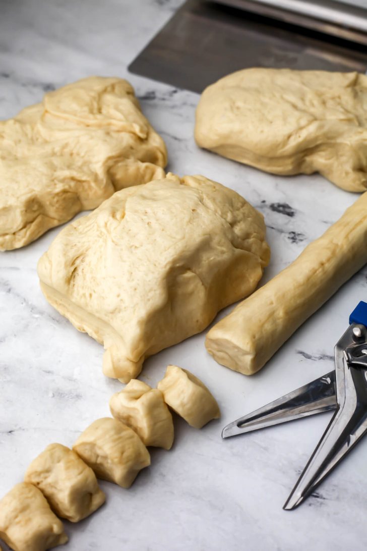 The vegan soft pretzel dough cut into fourths, then rolled into tubes and cut into pieces.
