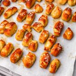 Vegan soft pretzel bites baked on a baking sheet covered with parchment paper.