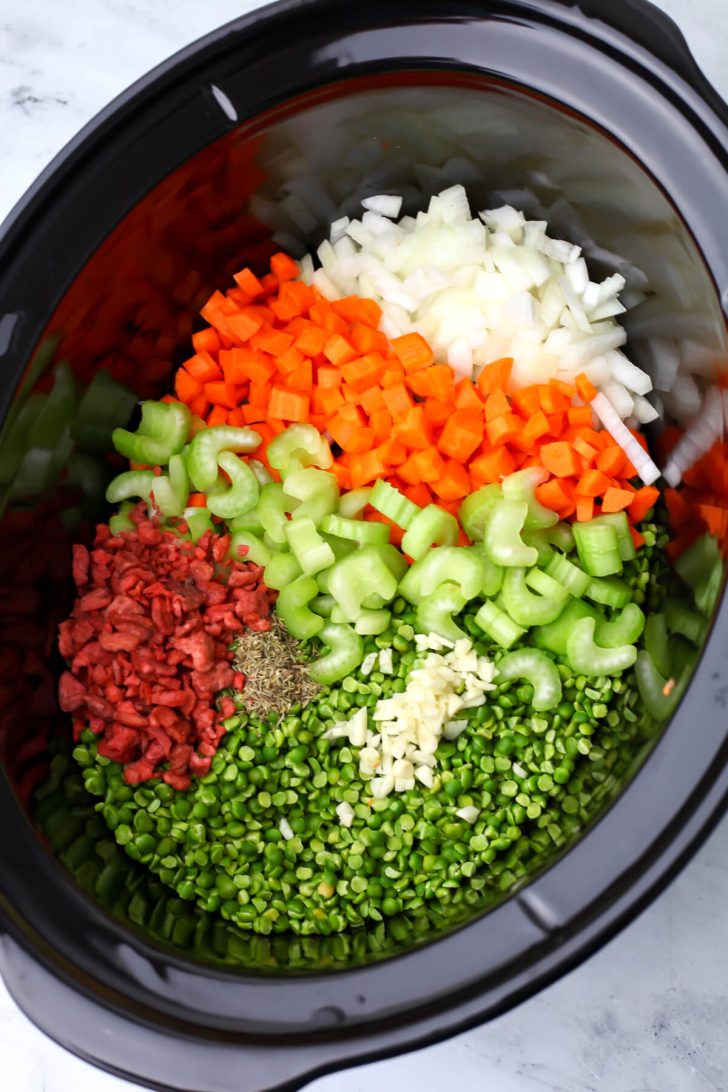 All of the ingredients except for broth added for vegan split pea soup added to a large slow cooker.