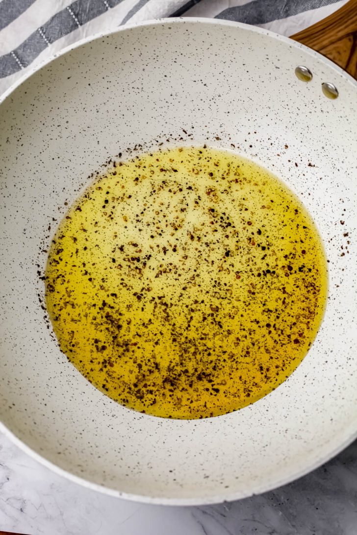 Olive oil with fresh ground pepper heating on low.