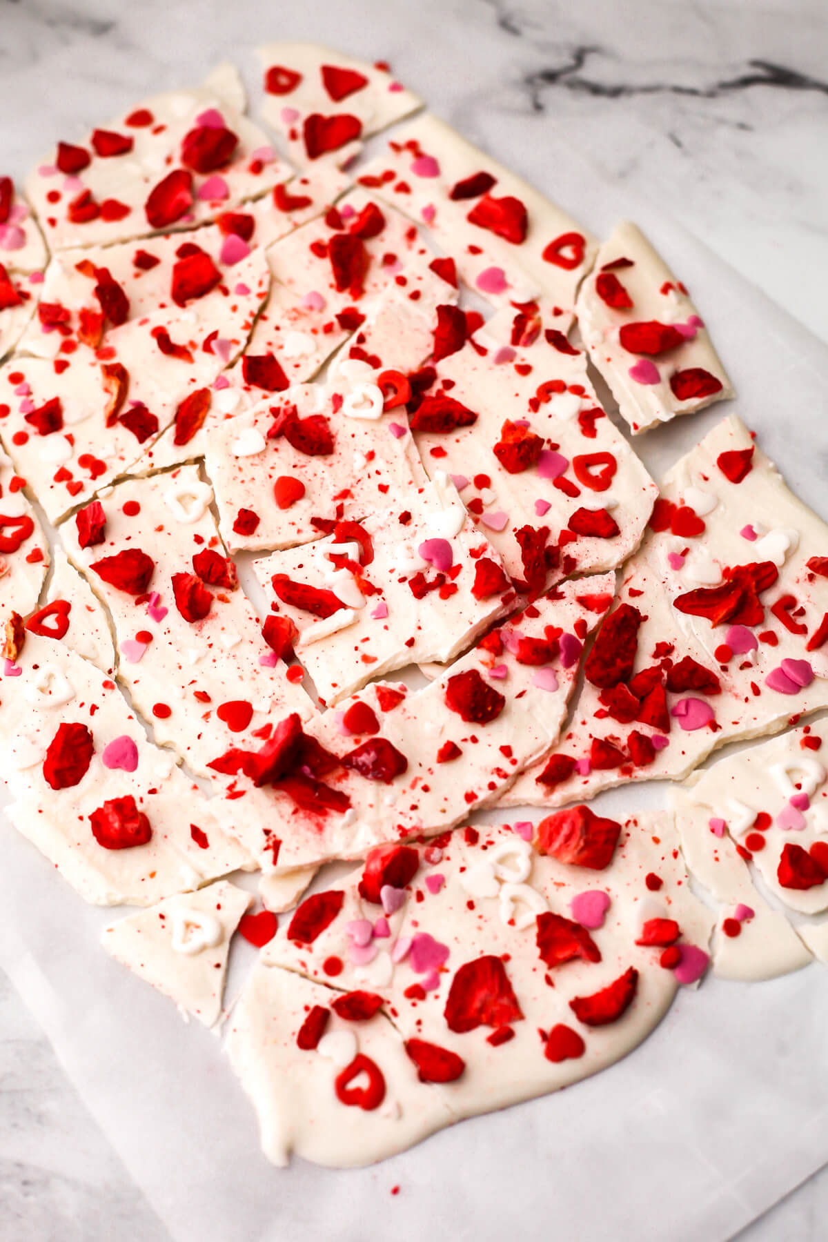 Vegan white chocolate bark on a parchment lined cookie sheet.