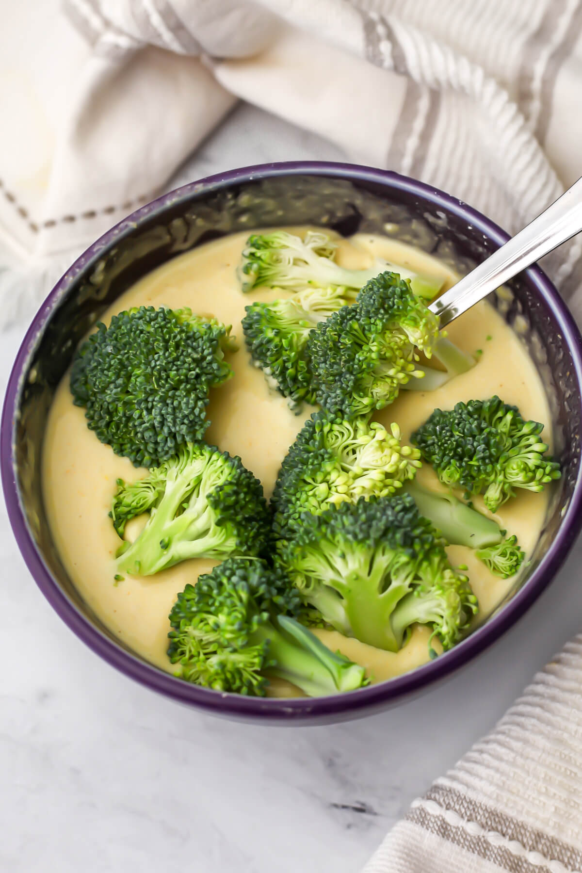 Broccoli florets in a prepared batter before frying.