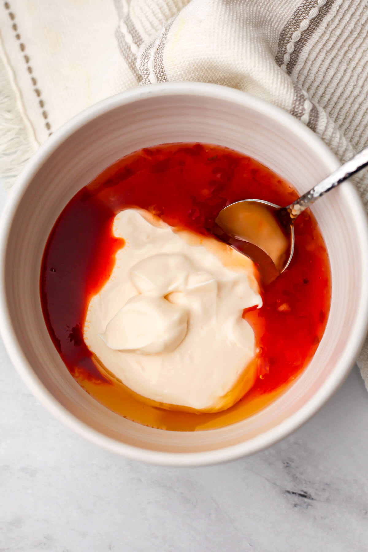 Vegan mayo, sweet chili sauce, sriracha, rice vinegar, and agave in a bowl to make vegan bang bang sauce.