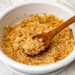 A white bowl filled with seasoned vegan breadcrumbs.