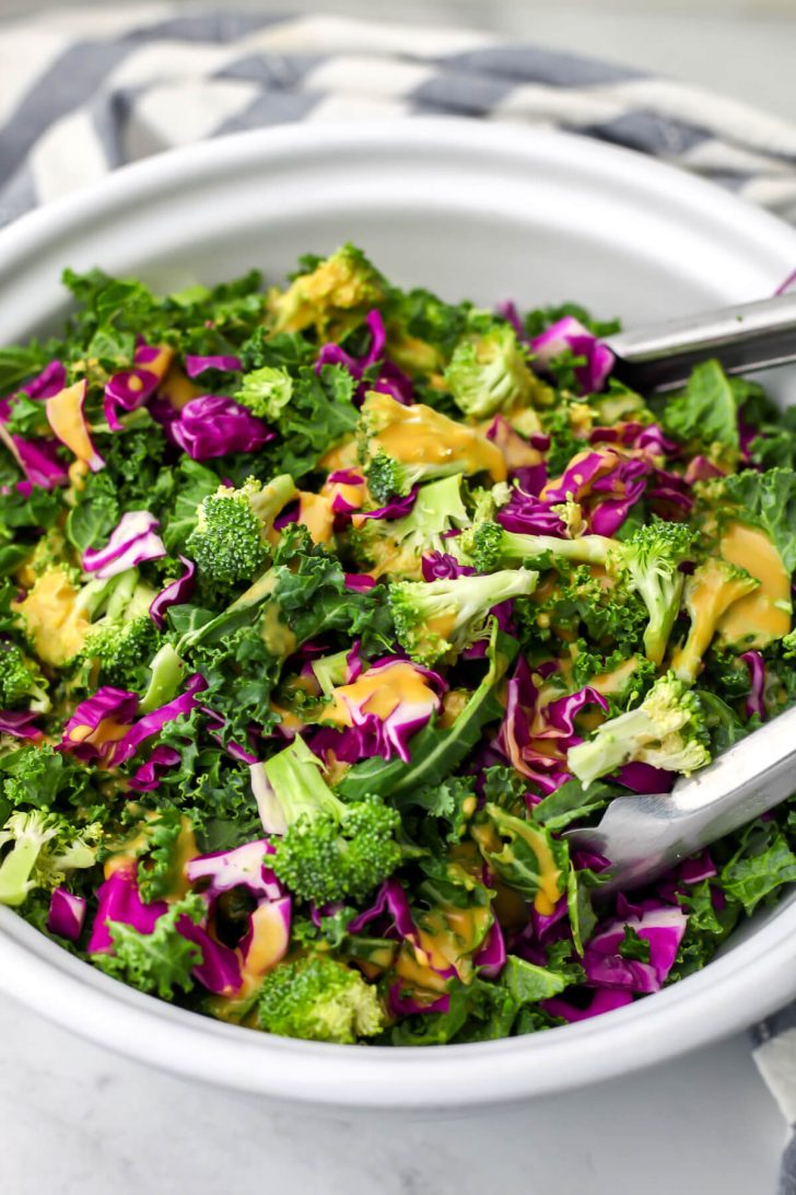Nutritional yeast dressing poured over kale salad.