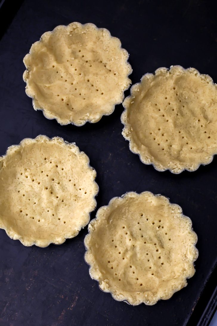 Vegan shortbread pressed into the bottom of tart pans.