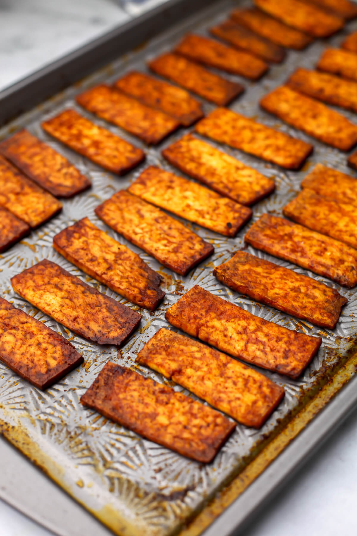 Smoky tofu strips baked on a sheet pan.
