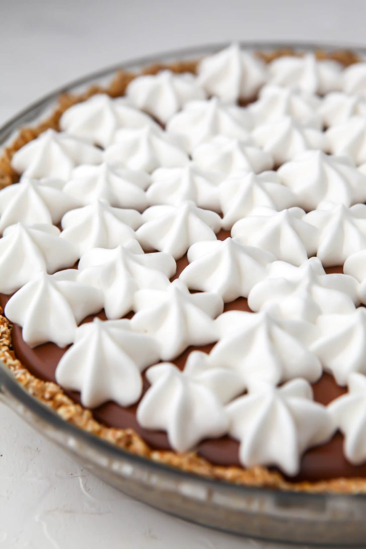 A vegan chocolate pie topped with vegan whipped cream.