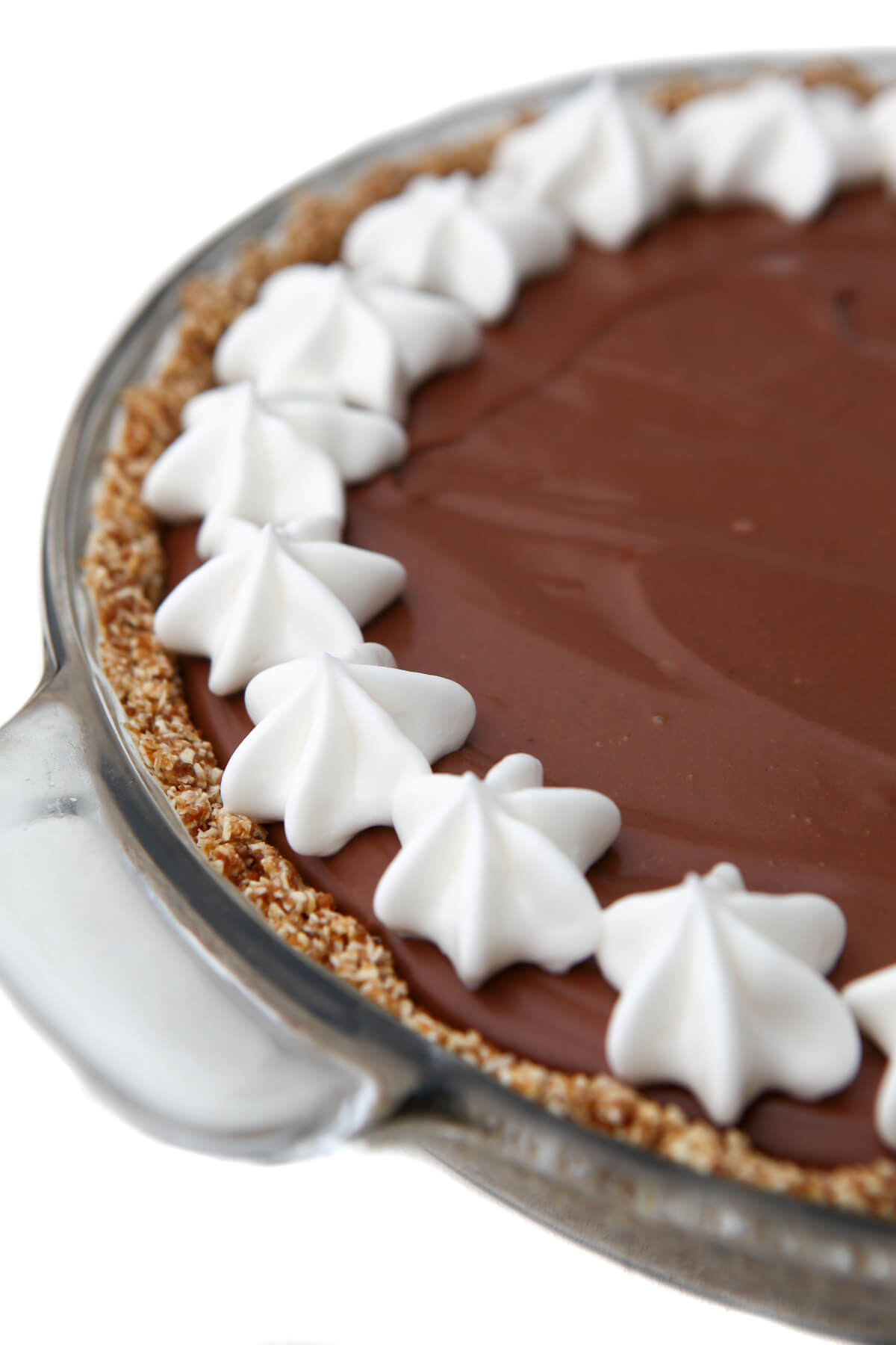 A vegan chocolate cream pie with a border of vegan whipped cream around the edge.