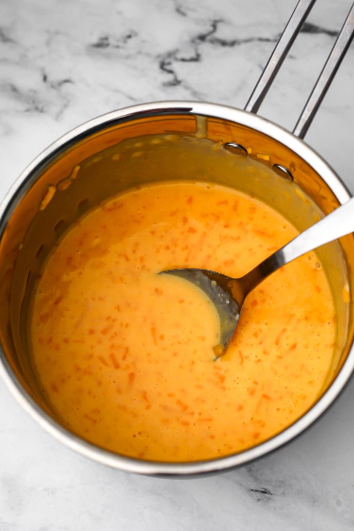 Vegan cheese sauce half melted in a sauce pan.