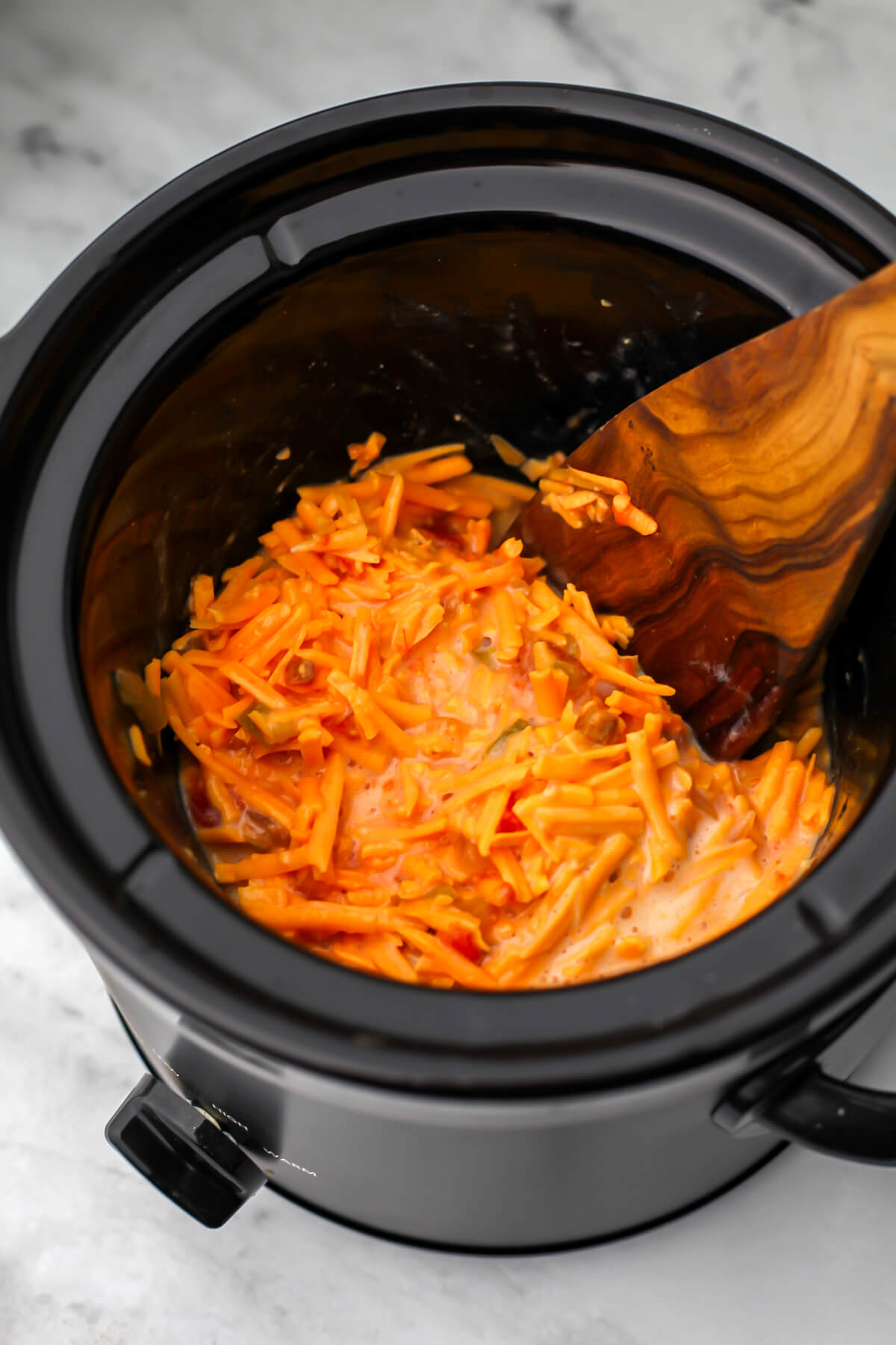 Vegan cheese, plant milk, and salsa in a slow cooker.