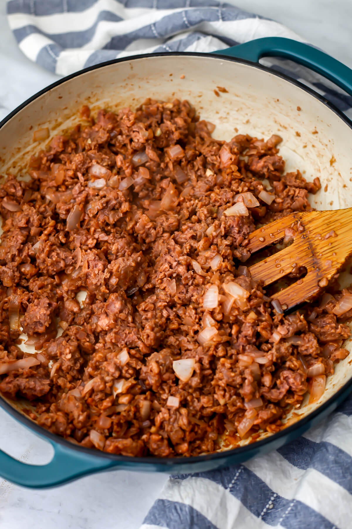 Sauteed onions with vegan hamburger meat added cooking in a large skillet.