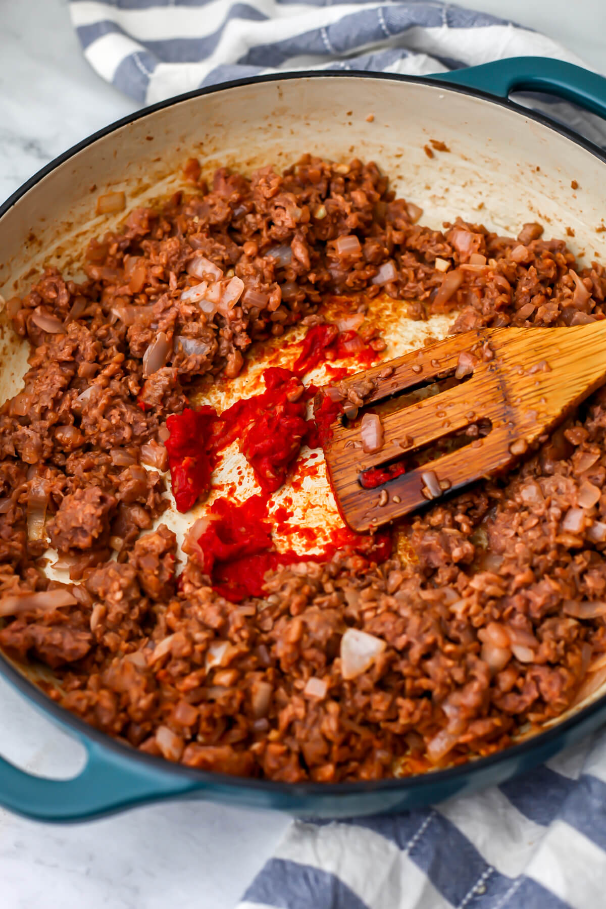 Tomato paste added to the cooked onions and vegan burger meat.