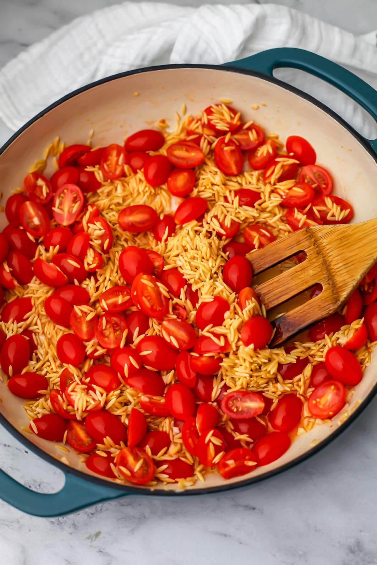 Dry orzo added to cherry tomatoes cooked in olive oil.