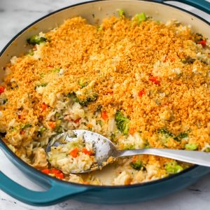 A blue skillet filled with a vegan chicken broccoli and rice dish topped with garlic breadcrumbs.