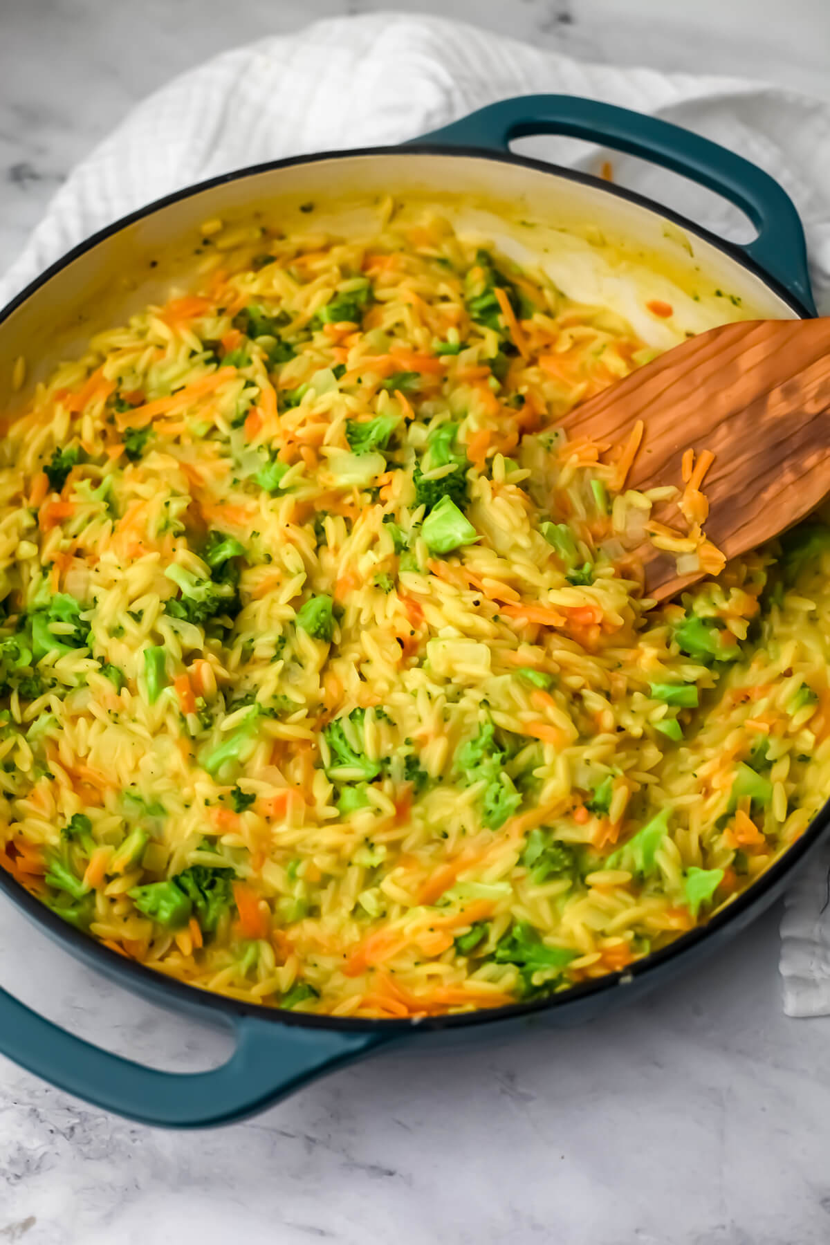 Vegan broccoli cheddar orzo in a blue skillet.