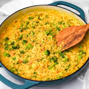 A blue skillet filled with vegan broccoli cheddar orzo.