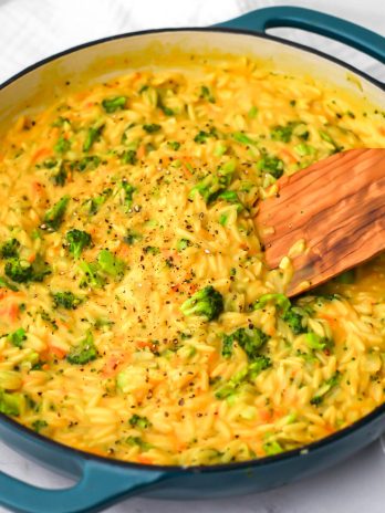 A blue skillet filled with vegan broccoli cheddar orzo.
