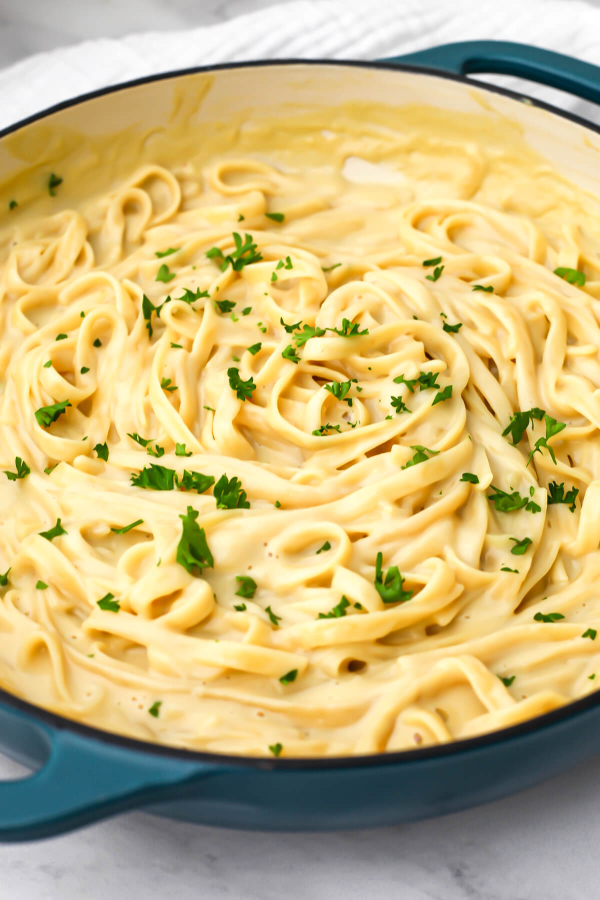 Oat milk alfredo in a large blue pot.