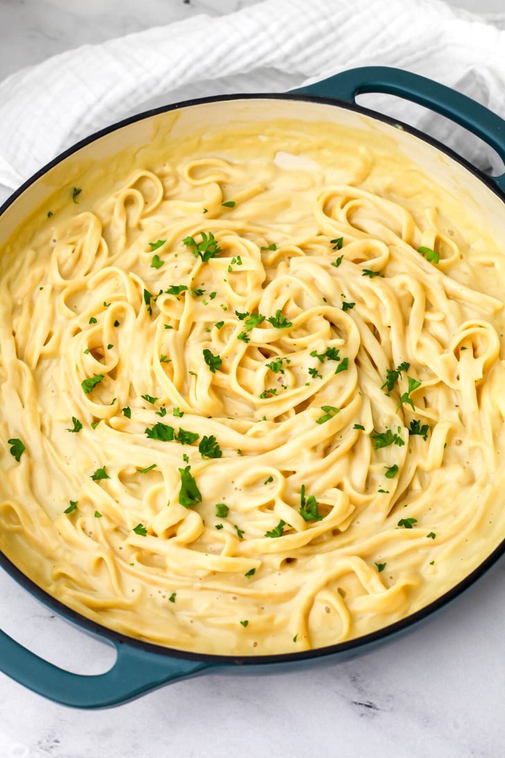 Vegan oat milk alfredo in a large blue pan.